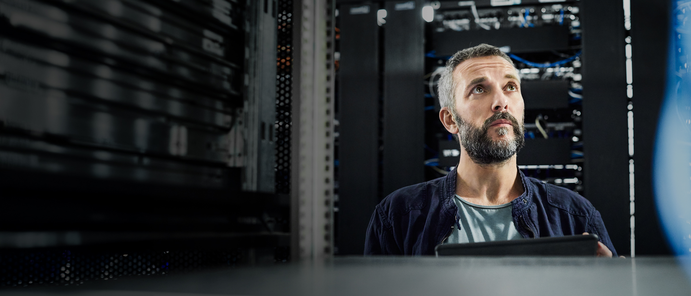 Tech worker at a desk looking at a monitor displaying a network architecture in the Cisco Networking Cloud