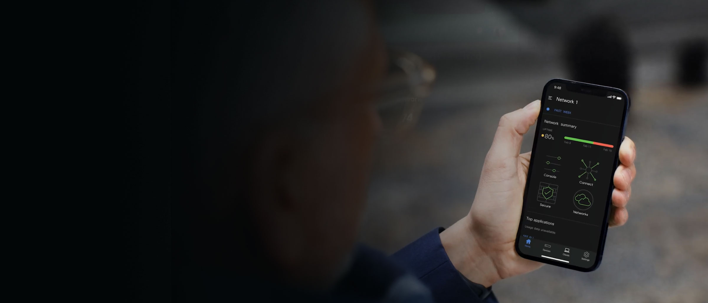 Hand holding a smartphone showing a network summary on the screen