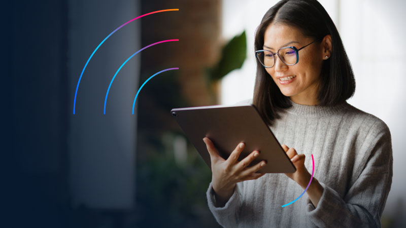 Woman on tablet device with wireless signal icon to her left.