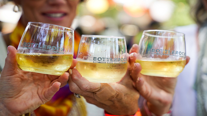 Three people holding up wine glasses at BottleRock